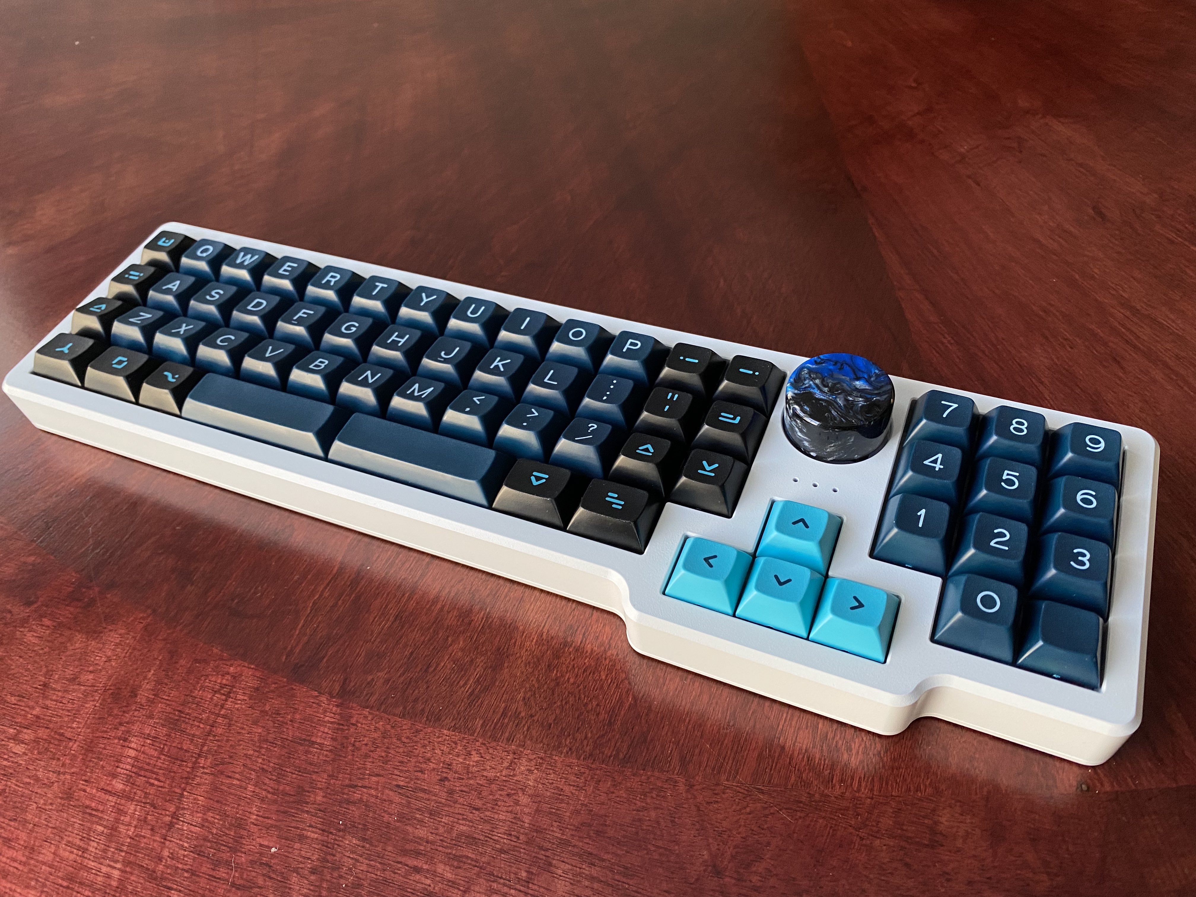 A white cerakoted Garbage Truck with a gORTHage Truck PCB, DSS Solarized Dark keycaps, and custom resin knob
