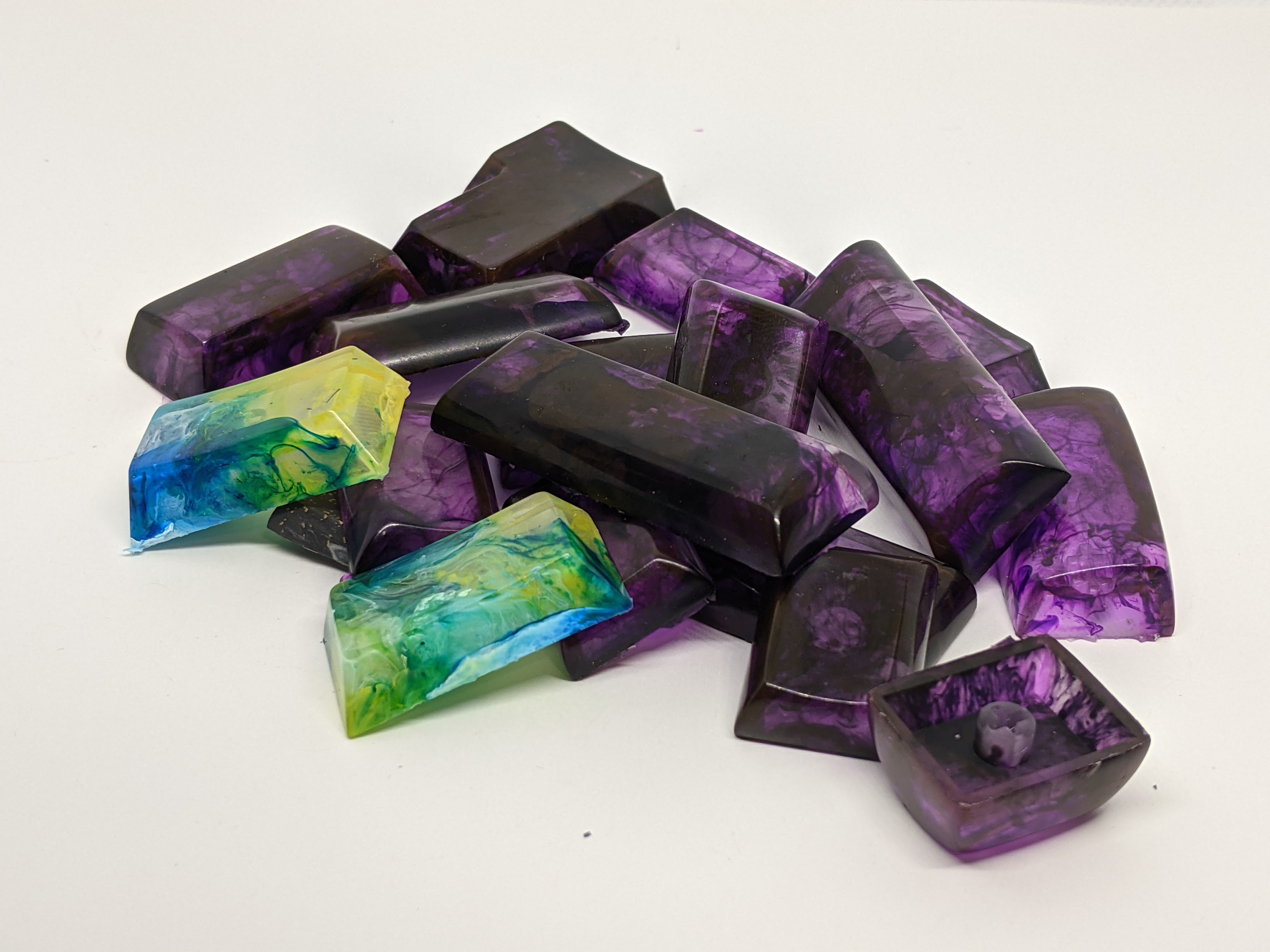 A pile of Asymplex resin keycaps in various profiles
