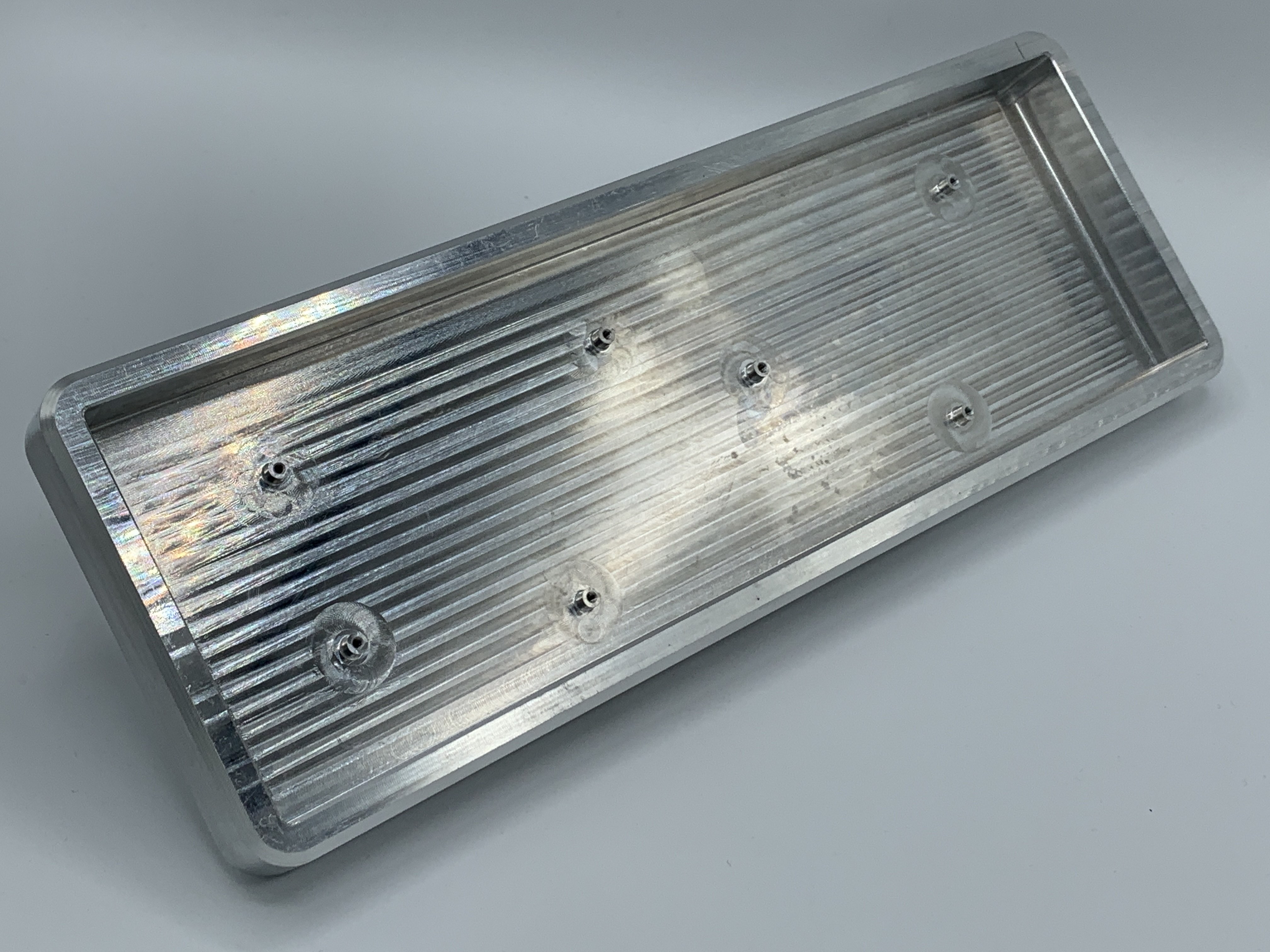 Raw aluminum MFR prototype showing tray mount holes and high-profile design