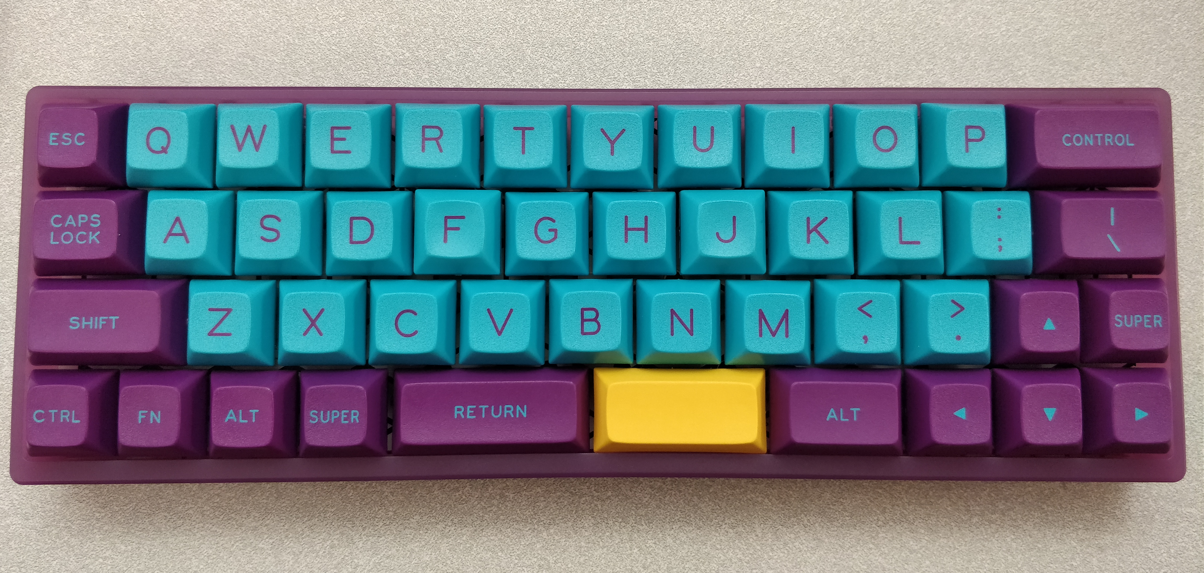 A MiniVan with DSA Skeletor keycaps in an Atom case. Note the inward bowing of the case plastic near the spacebars.